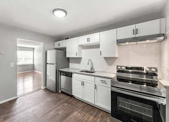 a kitchen with stainless steel appliances and white cabinets at Gardens at Washington Park, Atlanta, Georgia