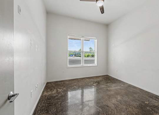 A room with a window and a ceiling fan.