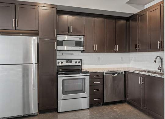 A kitchen with brown cabinets and a white refrigerator.