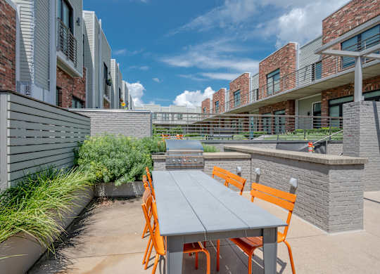 A patio with a table and chairs is surrounded by buildings.