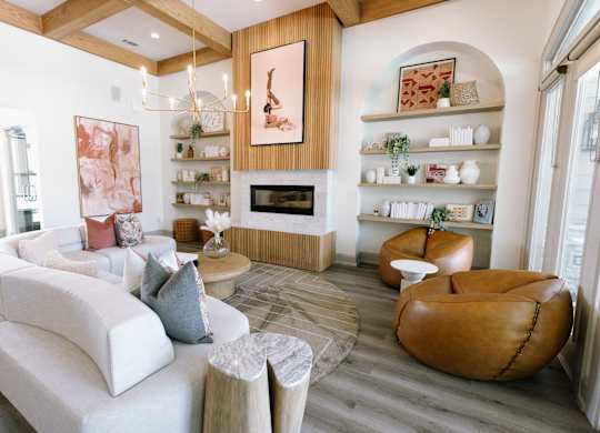A living room with a white couch and a brown leather chair.