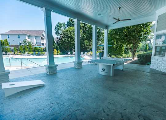 A poolside patio with a table and chairs.