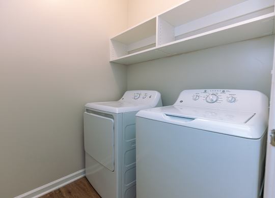 Two white front loading washing machines in a laundry room.