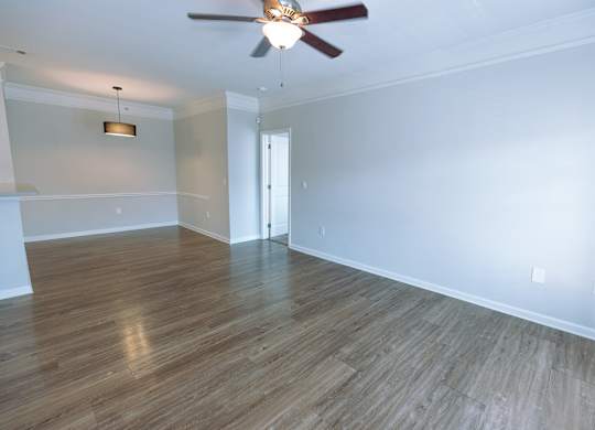 A room with a ceiling fan and wooden flooring.
