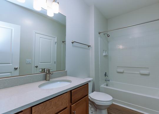 A white bathroom with a toilet, sink, and bathtub.