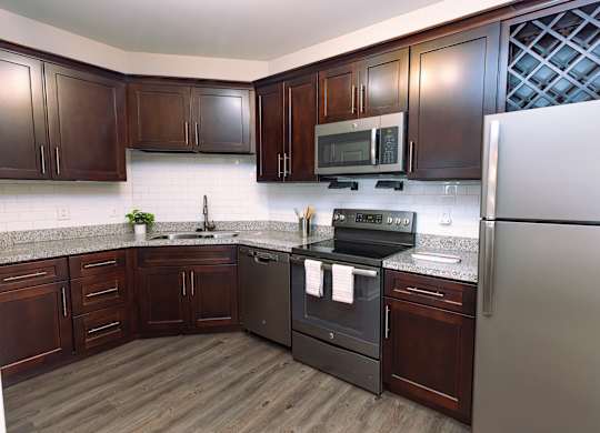 A kitchen with dark wood cabinets and a white refrigerator.