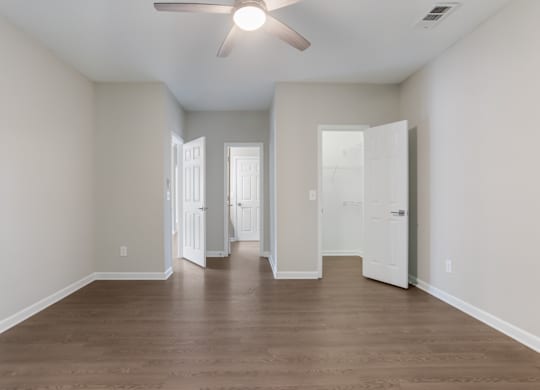 A room with a ceiling fan and wooden flooring.