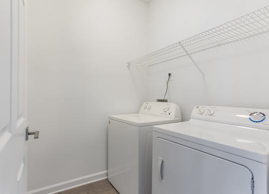 A white laundry room with a washer and dryer.