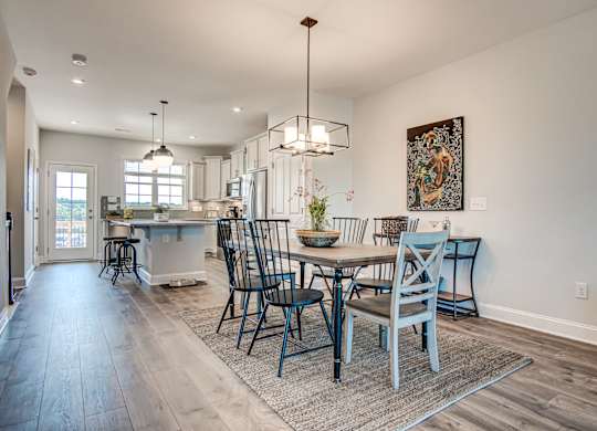 a dining room and kitchen with a table and chairs