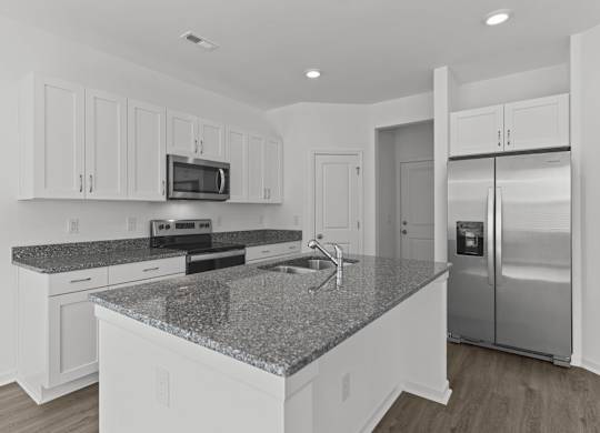 a white kitchen with granite counter tops and stainless steel appliances