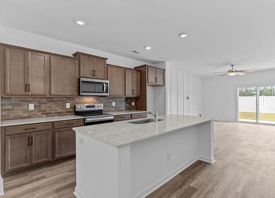 A kitchen with brown cabinets and a white island.