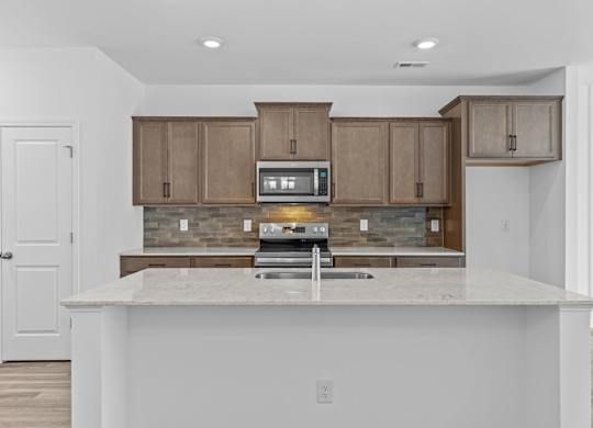 A kitchen with a white counter top and brown cabinets.