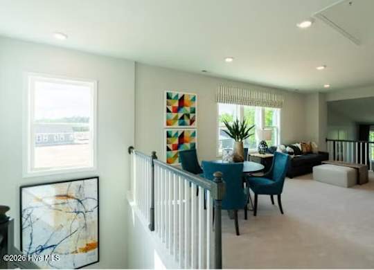 A living room with a white railing and a painting on the wall.