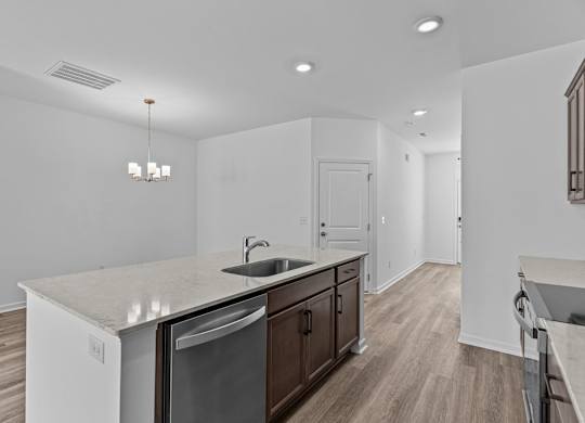 A kitchen with a sink, stove, and cabinets.