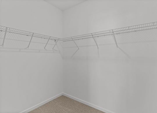 an empty closet in a white room with white walls and shelves