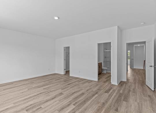 A room with wooden flooring and white walls.