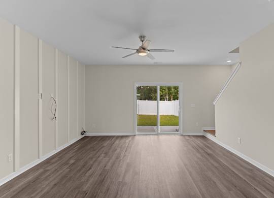 A room with a ceiling fan and wooden flooring.