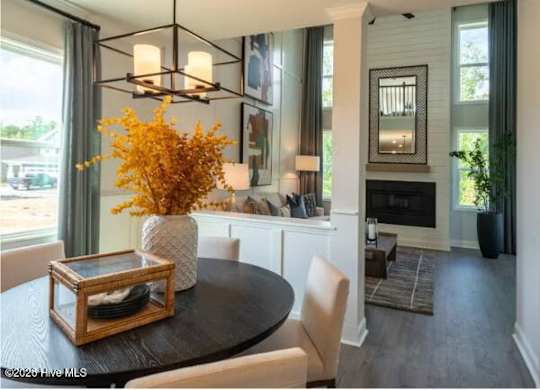 A dining room with a table set for two and a fireplace.