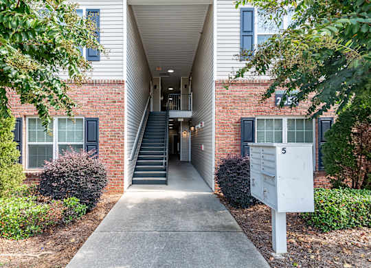an exterior view of a brick building with stairs and a sidewalk