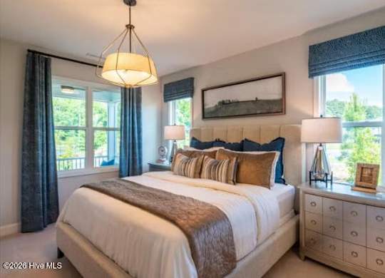 A bedroom with a large bed, a nightstand with a lamp, and a painting on the wall.