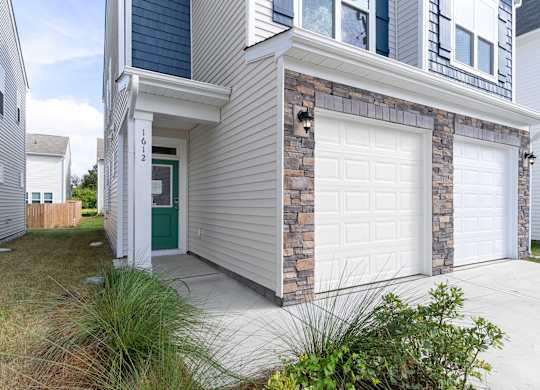 the front of a house with two white garage doors