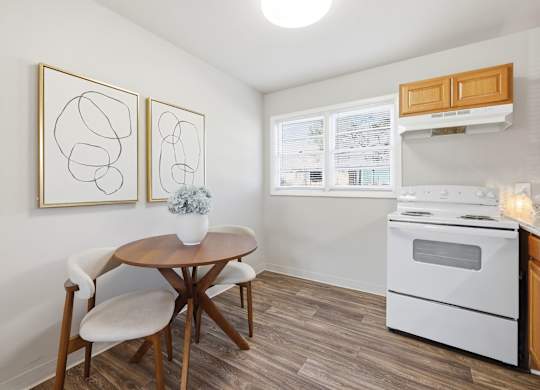 A kitchen with a table and chairs and a white oven.