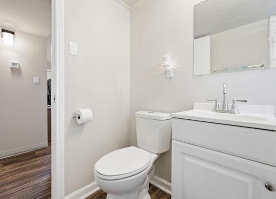 A white toilet sits next to a sink in a bathroom.