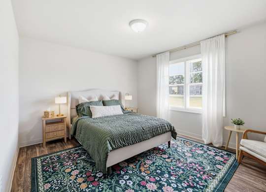 A bedroom with a bed, nightstands, and a rug.