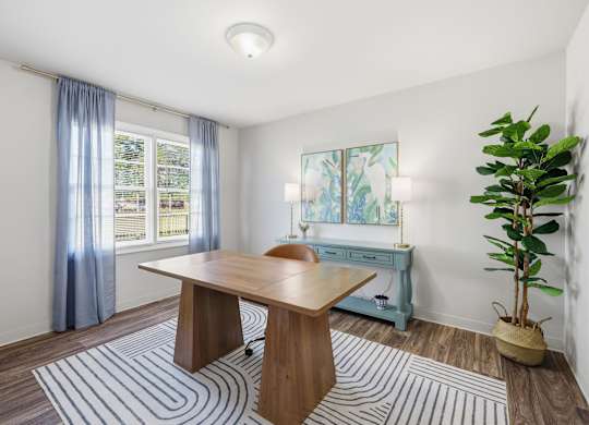 A room with a table, a plant, and a window with curtains.