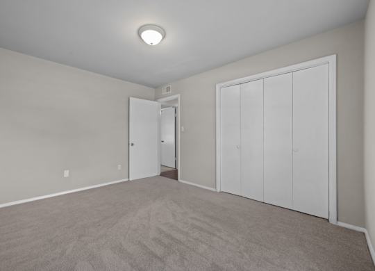 A room with a carpeted floor and a ceiling light.