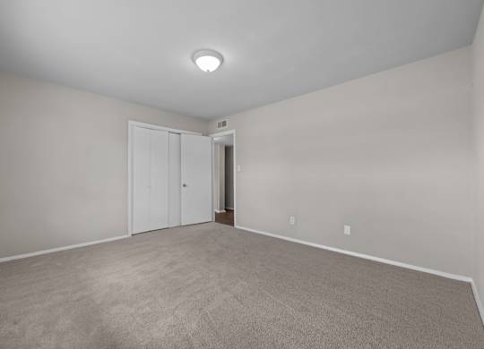 A room with a carpeted floor and a white ceiling with a light fixture.