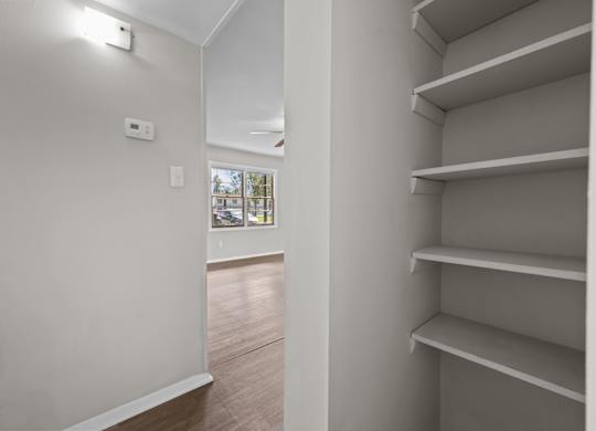 Empty shelves in a room with a window.