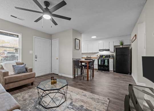 A living room with a brown couch and a glass coffee table.