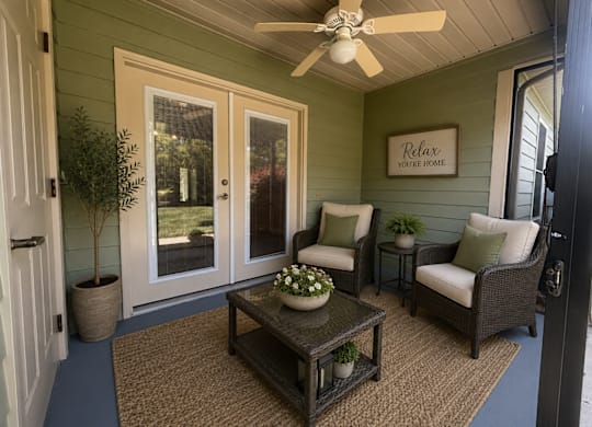A patio with a table, chairs, and a ceiling fan.