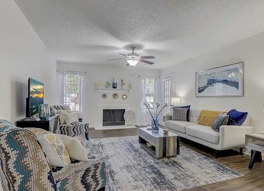 A living room with a couch, a chair, a coffee table, and a painting on the wall.
