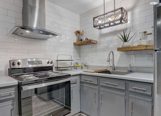 A modern kitchen with stainless steel appliances and white subway tiles.