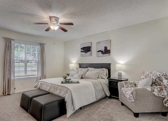 A bedroom with a large bed and a chair.