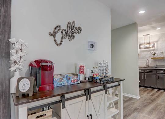 A coffee bar area with a coffee machine and a coffee sign on the wall.