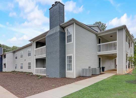 A modern two-story house with a grey exterior and a chimney on the roof.