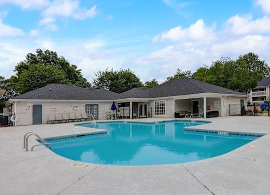 A large outdoor swimming pool with a building in the background.