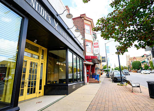 a sidewalk in front of a store on a city street
