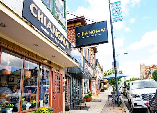 a city street with a chiangmai sign on the side of a building