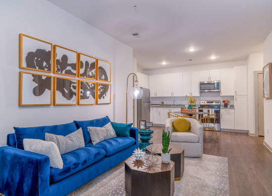 a living room with a blue couch and a kitchen in the background at Carmel Vista, McDonough, 30253
