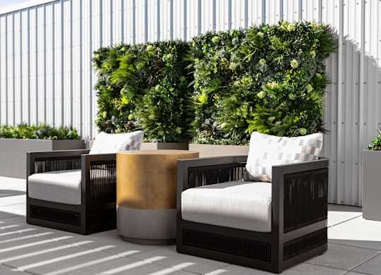 an outdoor seating area with furniture and a green wall