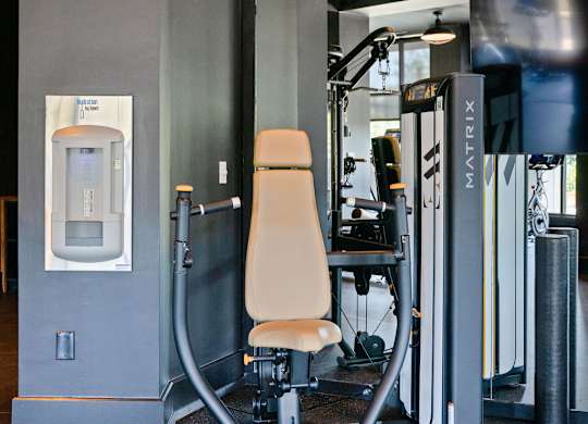 a workout room with a chair and a punching bag on the wall