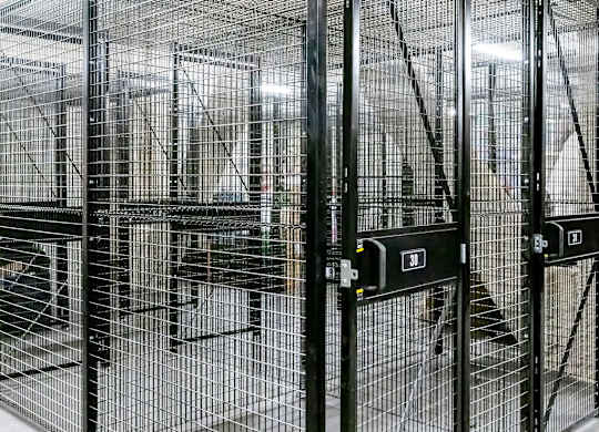 a group of cages in a building with doors