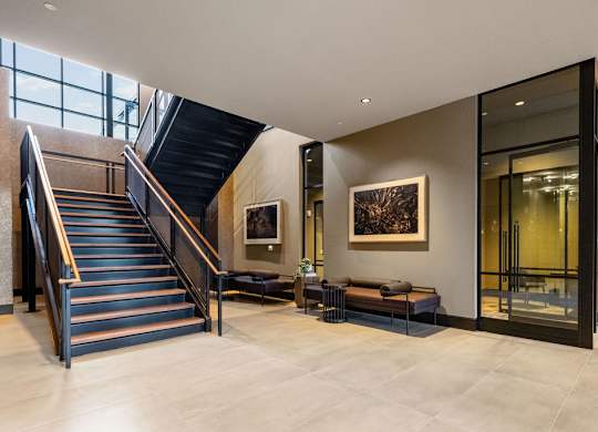 a staircase in the lobby of a building with a glass door