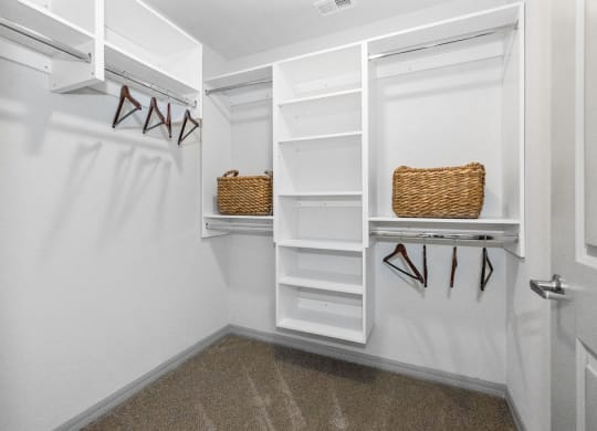 a walk in closet with white shelves and a white closet door at Inspira, Naples, 34113