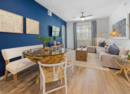 a living room with a blue accent wall and a table at Inspira, Naples, FL, 34113