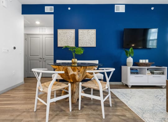 a dining room with a table and chairs and a tv at Inspira, Naples, Florida